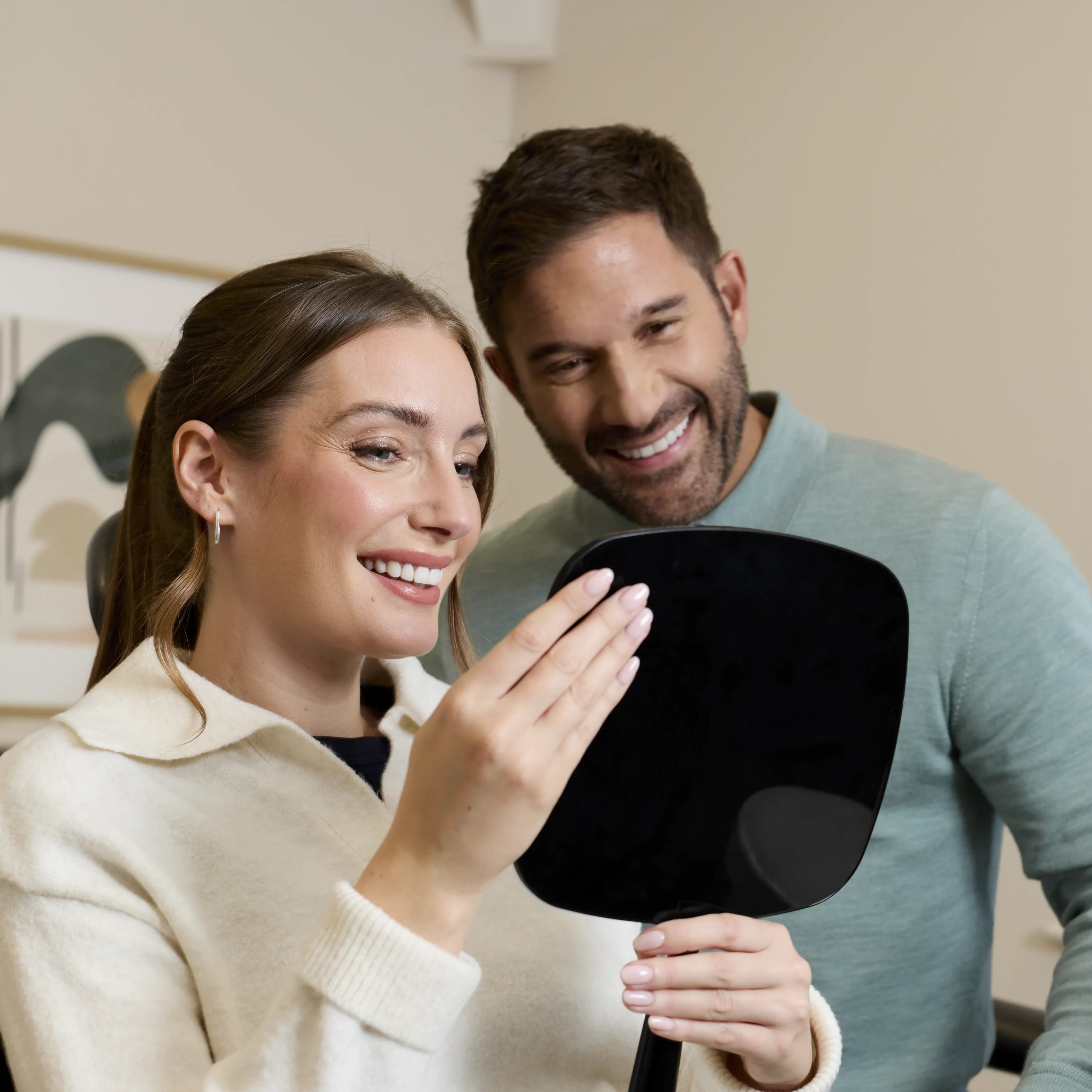 IU porcelain veneers patient being shown the result in a mirror